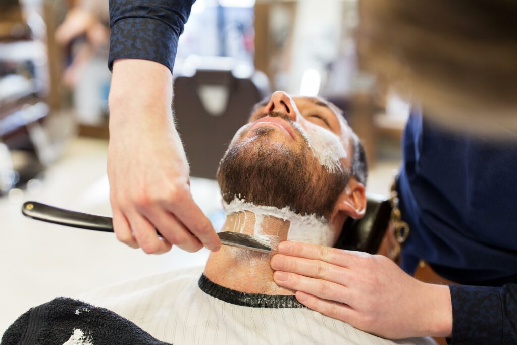 hombre y barbero con barba afeitada