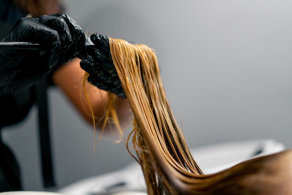 peluquero aplicando tratamiento keratina en un salón de belleza