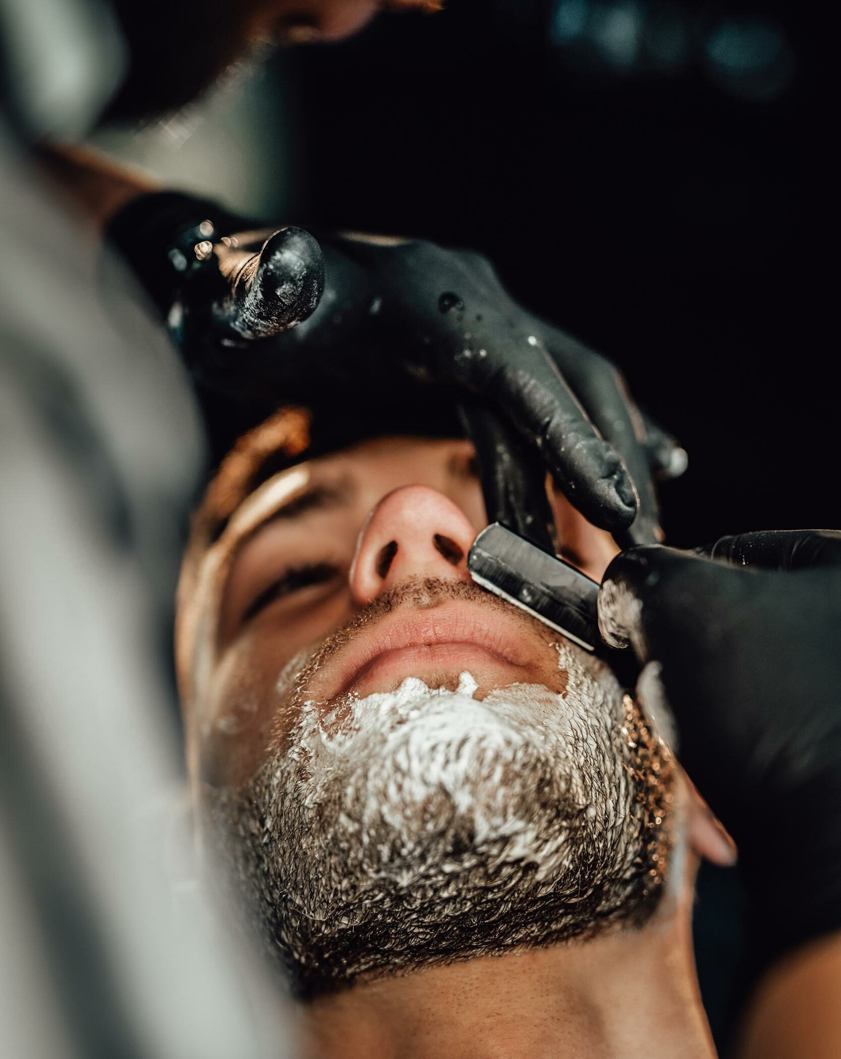 un hombre afeitado por un peluquero profesional