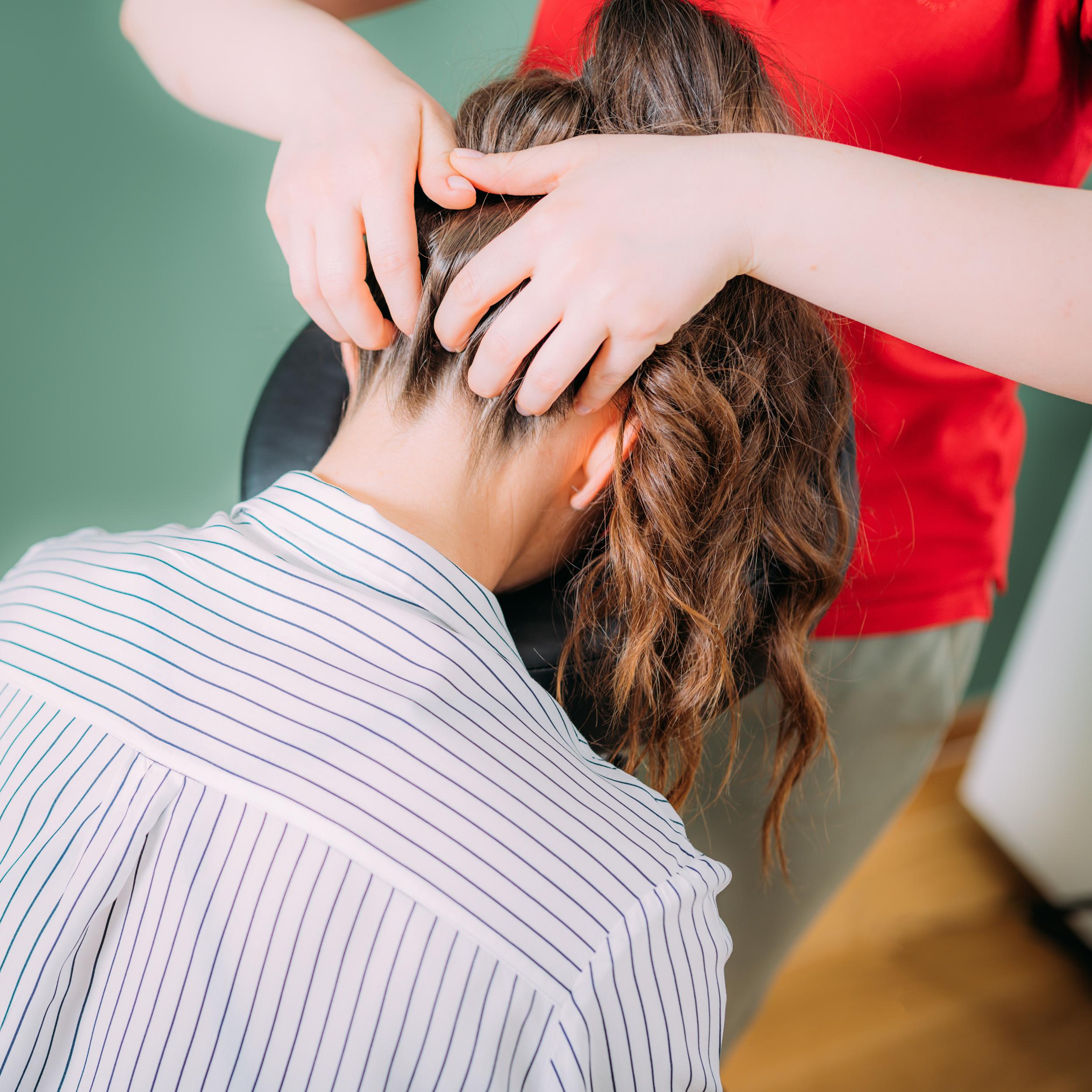 masaje cabello de una mujer sentada en una peluqueria