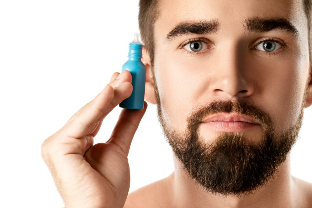 Hombre sosteniendo un frasquito para las ojeras