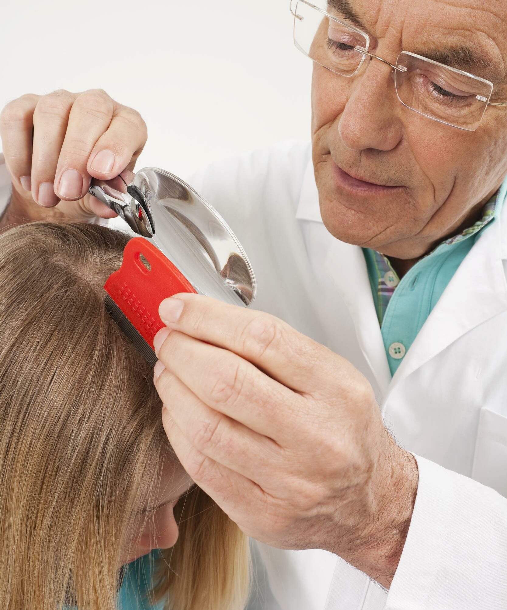 doctor mirando el cabello de una niña